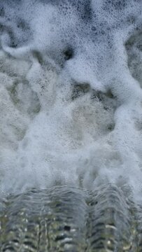 Water falls from the dam. Waterfall, top view. Streams of water. Water foam.