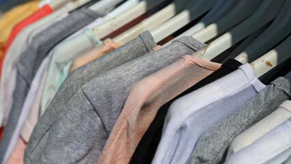 Close-up of various T-shirts on hangers for sale