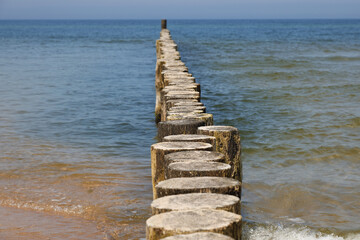 Fototapeta premium Coastal protection against sea waves by breakwaters driven into the seabed