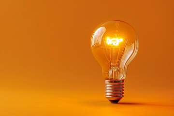 Image of a glowing light bulb on an orange background