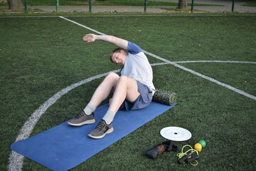 A young man in sportswear engages in a workout, using a sport tool for physical exercises on a...