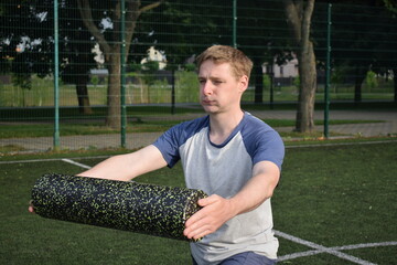 A young man in sportswear engages in a workout, using a sport tool for physical exercises on a...