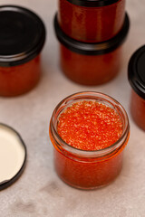 Jars of red caviar, freshly salted caviar at home