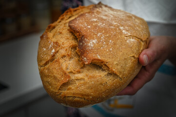 Woman with fresh baked sourdough bread in kitchen 1