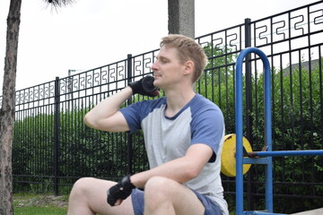 A young man in sportswear engages in a workout, using a sport tool for physical exercises on a...
