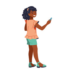 Joyful and stylish young African American girl with curly hair happily taking a selfie on her smartphone. She is exuding confidence and happiness, dressed in a trendy outfit. The background is white.
