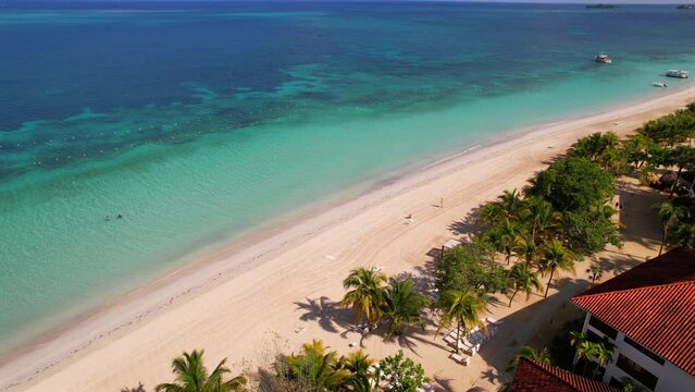 Solitary man talking into the Caribbean sea with clear turquoise water  in Jamaica on the 7 Mile Beach. Tropical summer vacation and nature environment concept