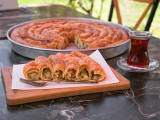 Turkish Yen Boregi filled with mince meat served with tea at an outdoor cafe in Izmir, Turkey