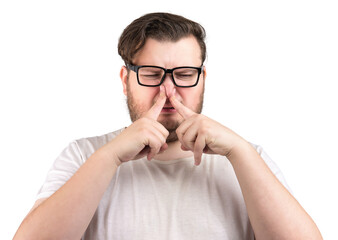 man pinches nose with fingers with disgust something stinks bad smell isolated on white background. 