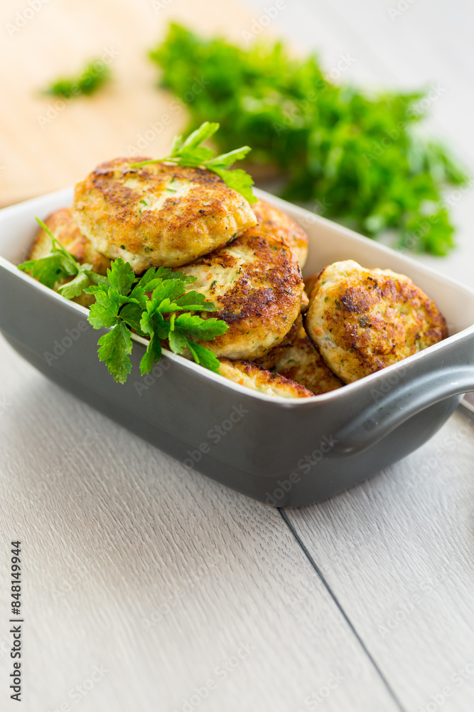 Poster fried meat cutlets in a ceramic form on a wooden table