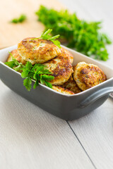 fried meat cutlets in a ceramic form on a wooden table
