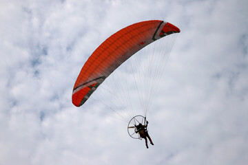 Paramotor vehicle flying over  blue sky, Powered paraglider
