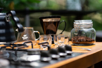 photo of teapot, glasses and coffee brewing equipment on an aesthetic table.