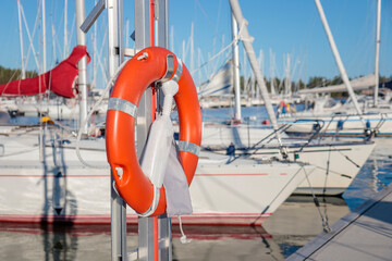 SOS nautical emergency concept. Lifebuoy, orange lifebelt put on vertical ready for using. Close up...