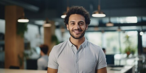 Obraz premium Man sitting at desk with friendly expression, great for corporate or professional use