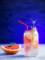 Refreshing chilled summer lemonade with grapefruit slices. Decorated with a sprig of rosemary