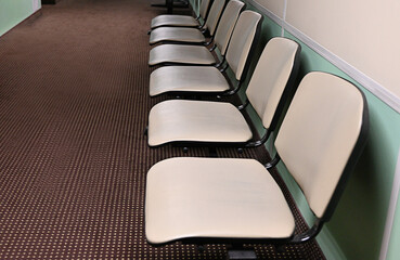Empty hospital waiting room in lobby with reception counter at medical facility, used to help patients with appointments and healthcare insurance. Medical waiting area with front desk.