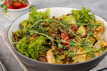 Salad with duck breast and croutons, tomatoes, lettuce and sauce. Boiled egg.