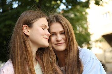 Obraz premium Portrait of two beautiful twin sisters outdoors
