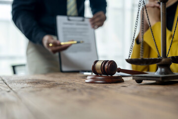 A man is standing in front of a scale with a document in his hand