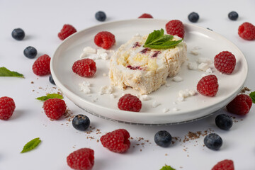 Raspberry meringue roll on a white plate close-up. Dessert on a white background. Breakfast decorated with berries