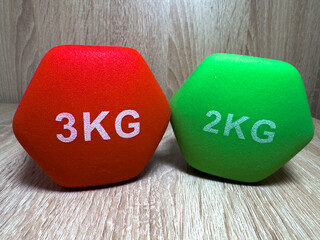 Colorful Hexagonal Dumbbells on Wooden Surface