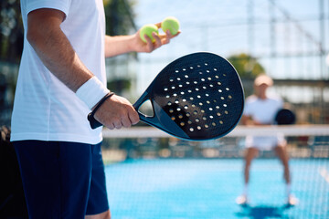 Close up of paddle tennis player serving  ball. © Drazen