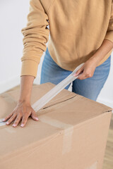 Happy young woman packing her things to move to her new house. She is a homeowner, mortgage concept. New home, new life