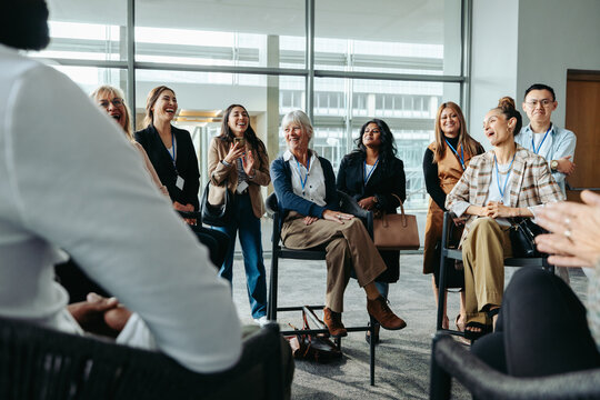 Diverse group of colleagues laughing during an office meeting in a modern workspace