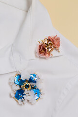Two decorative handmade brooches on the collar