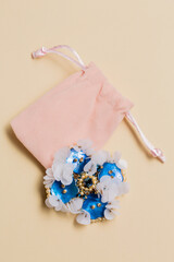 Handmade blue brooch on a plush bag