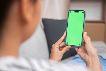 Lady browses information on smartphone with chromakey closeup female student gains new knowledge watching online lessons at home backside view distant education