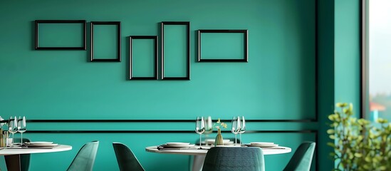 A contemporary dining room with a teal wall, featuring five small empty black frames in a random pattern.