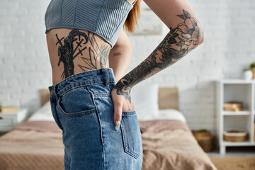 A young woman with tattoos relaxes in her modern apartment on a cozy weekend.