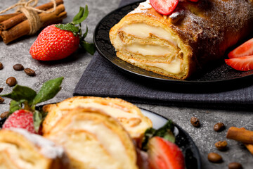 Sliced rolls with custard. The dessert is decorated with fresh strawberries.