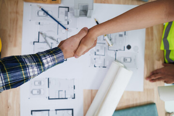 group of businessmen and investors join hands to symbolize cooperation in investing in real estate...