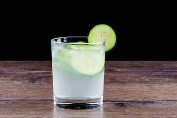 Cucumber non-alcoholic cocktail on a wooden table top.