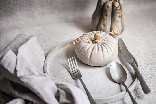 Elegant autumn dining table decor with pumpkins and utensils