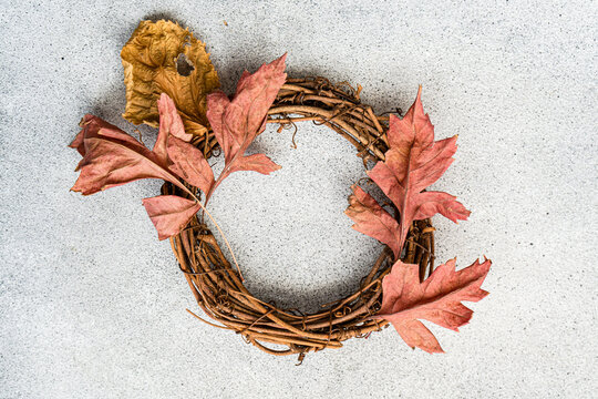 Autumn wreath with orange leaves on a gray background