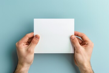 Male hands with blank sheet of paper on blue background