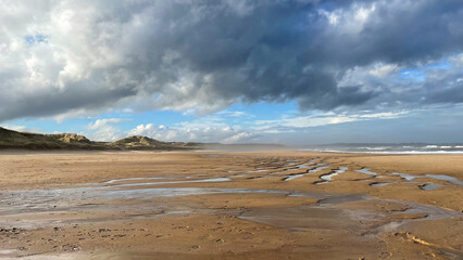 a beach with a sky that has clouds in it