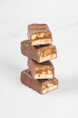 Vegan Candy bar. Nougat, caramel with peanuts, in milk chocolate. In the section. White background. 