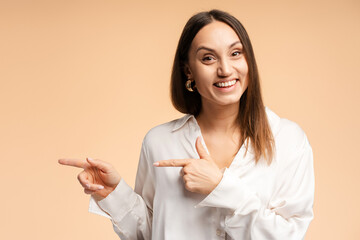 Portrait of smiling young woman with smile pointing fingers to the side, looking to camera