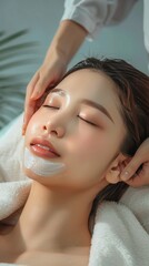 Naklejka premium Beautiful Asian Woman Enjoying Facial Treatment at Spa