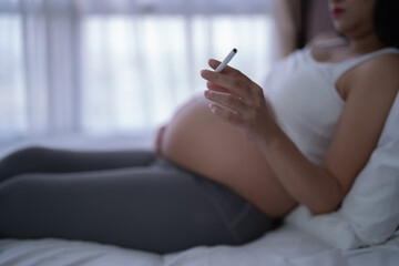 A Portrait of Asian pregnant woman smoking cigarette. Having a baby. Family people lifestyle. Mom...