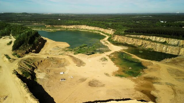 Lake Surrounded by a Dolomite Quarry &ndash; Drone View A striking drone-captured image showcasing a serene lake nestled within the rugged terrain of a dolomite quarry. The calm water contrasts with the qua