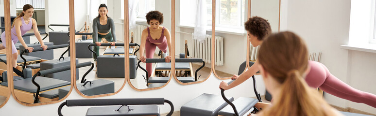 Sporty women engage in a Pilates session in a gym.