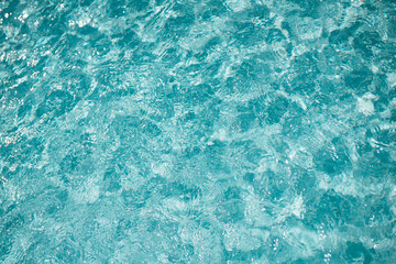 blue swimming pool water surface background reflecting summer sun light