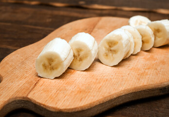 Appetizing sliced ​​banana on a kitchen cutting board close-up. Banana slices without peel