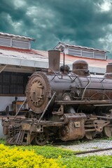 Naklejka premium An old steam locomotive on display at a train station